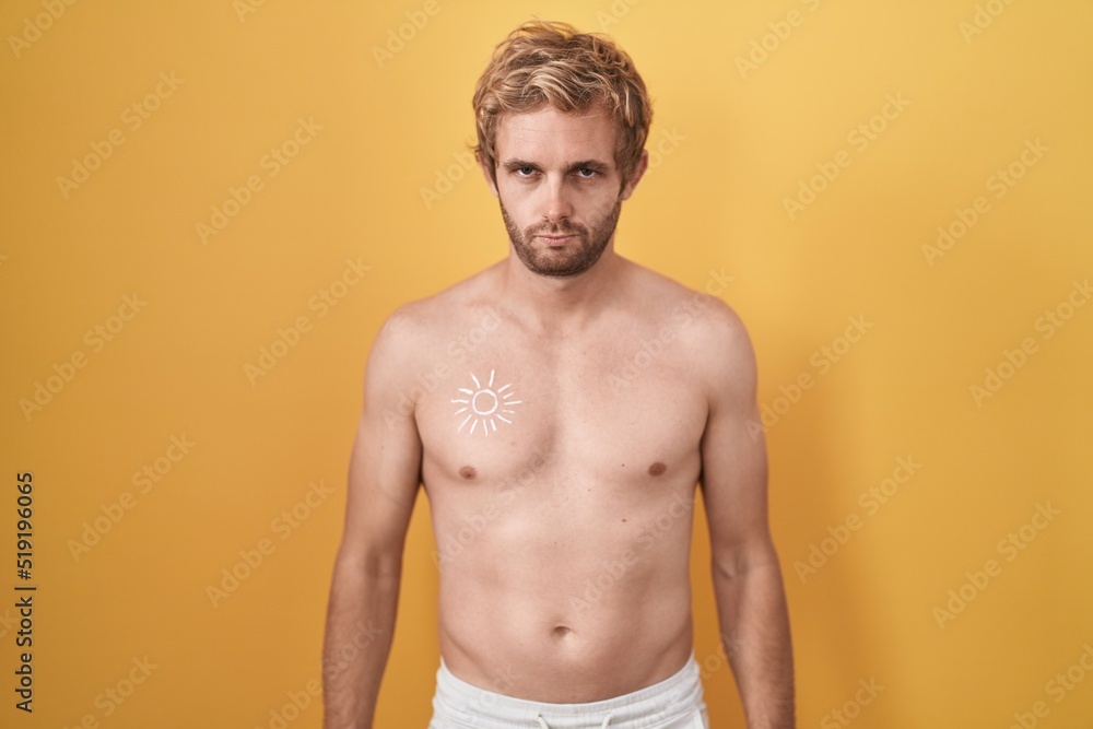 Caucasian man standing shirtless wearing sun screen skeptic and nervous, frowning upset because of problem. negative person.