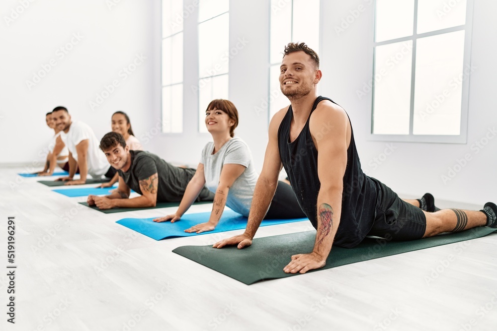 Group of young hispanic people smiling happy stretching at sport center. Group of young hispanic people smiling happy stretching at sport center.