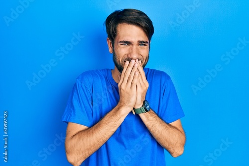 Obraz na płótnie Young hispanic man wearing casual clothes laughing and embarrassed giggle coveri
