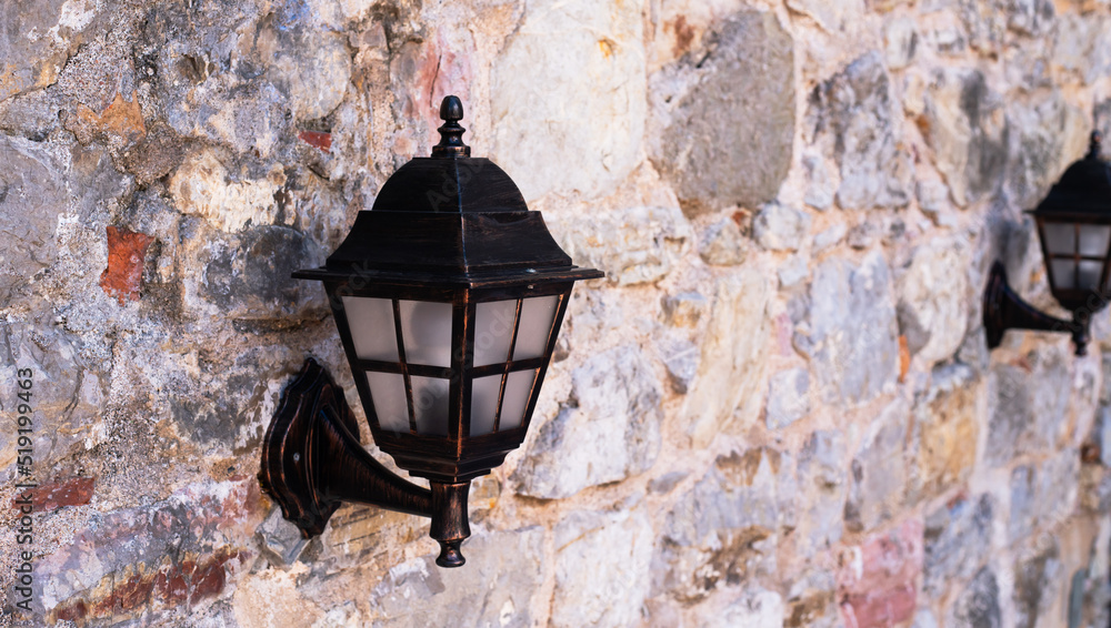 Vintage vintage lanterns on the wall in the old town. Side view. Selective focus.