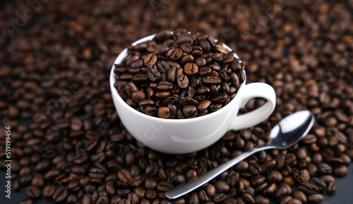 Aromatic coffee beans in a cup on a background of coffee beans. Close-up. Coffee day. Selective focus.