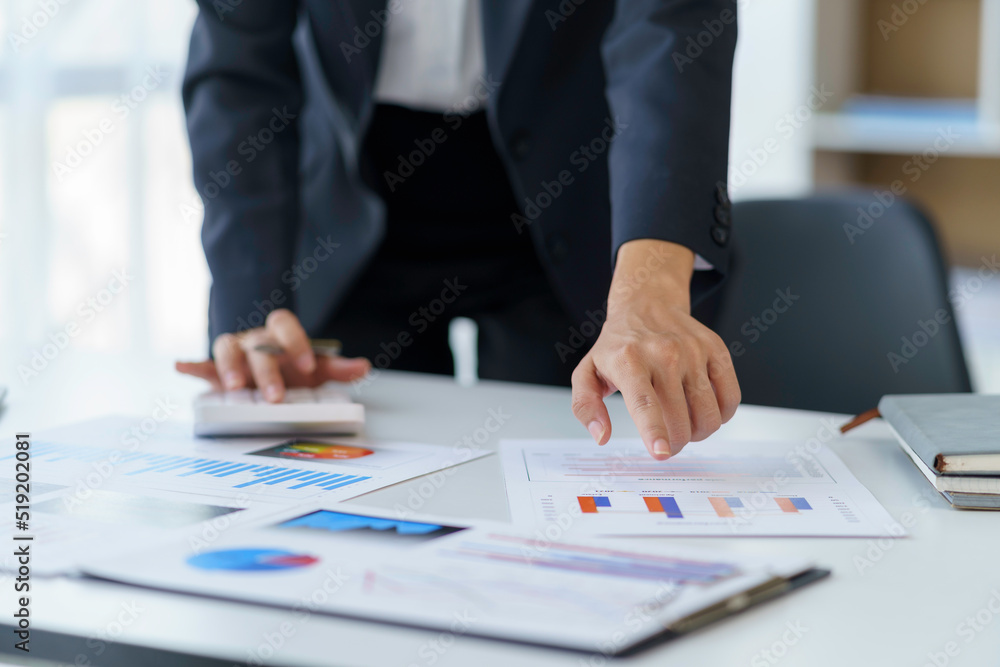 Close-up of a business woman analyzing charts and graphs for comparison each quarter, showing a change in market strategy. Close-up of a business woman analyzing charts and graphs for comparison each quarter, showing a change in market strategy.