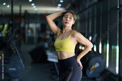 Beautiful Asian woman in a sporty workout clothes shows off her perfect figure to relieve the fatigue of gym workouts.