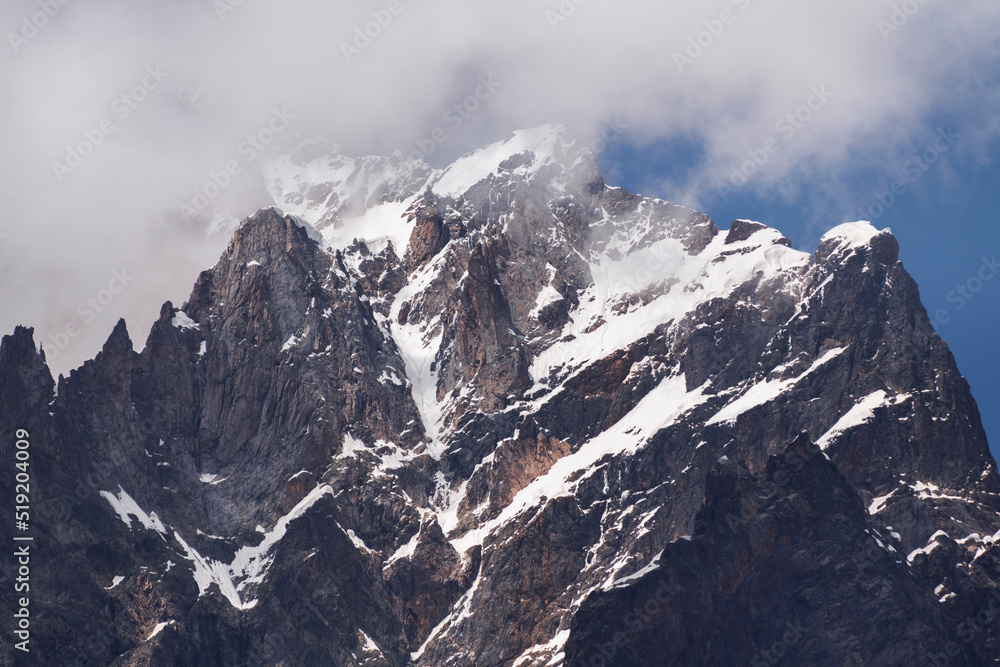 Amazing high rocks in a snow at the sunset. Mountains landscape