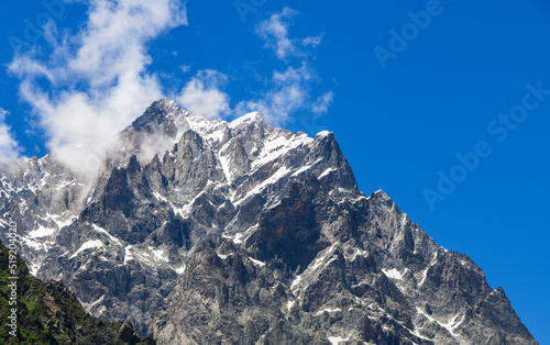 Mountains landscape. High snow covered mountains and rocks in the clouds.Georgia. Ushba mountains.