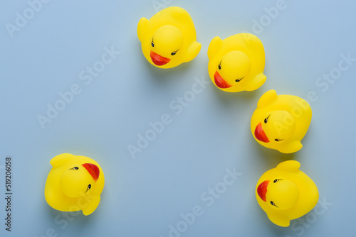 One rubber duck in front of group, announcement, education or meeting concept, on blue background top view