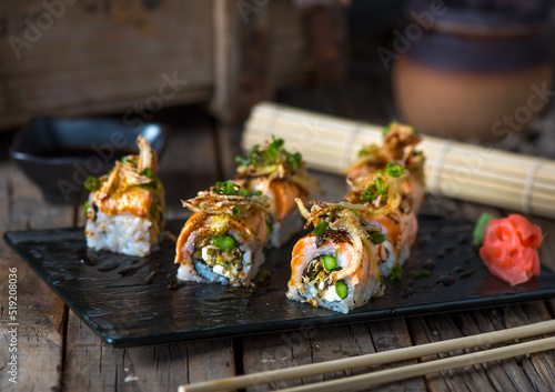 SALMON SKIN MAKI served in a dish isolated on wooden background side view