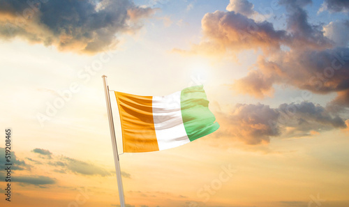 Cote d Ivoire national flag cloth fabric waving on the sky - Image photo