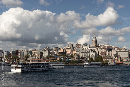 View of tour boats on Golden Horn area of Bosphorus in Istanbul. Galata tower and Beyoglu district are in the background. It is a sunny summer day. © theendup
