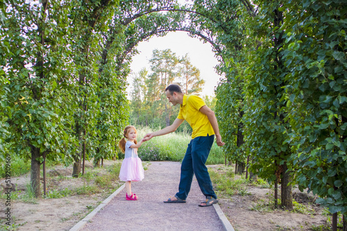 dad and daughter are dancing in nature.a little ballerina dances with her dad. daddy's daughter. little princess