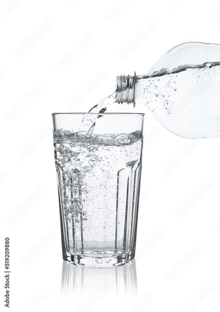 Pouring soda water from bottle into glass on white background Pouring soda water from bottle into glass on white background