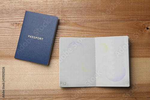 Foto Blank passports on wooden table, flat lay