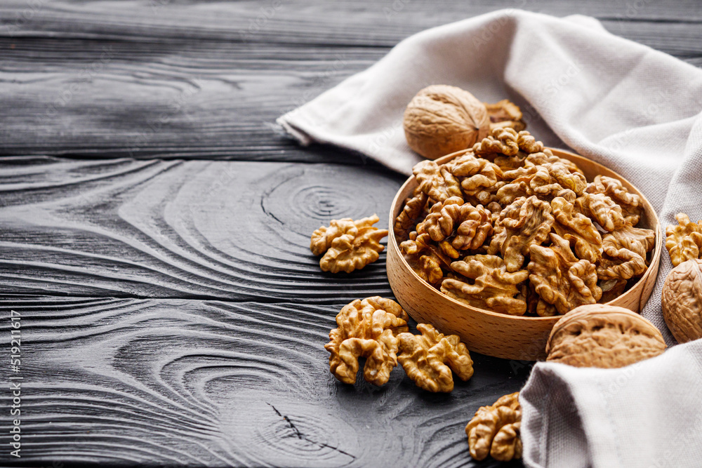 dried walnuts on a black rustic wooden background dried walnuts on a black rustic wooden background