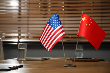 USA and China flags on wooden table in office. International relations