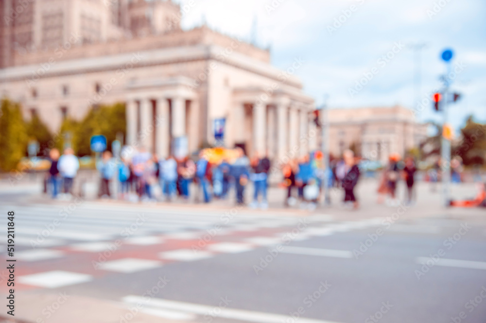 People waiting to cross street in city, blurred view