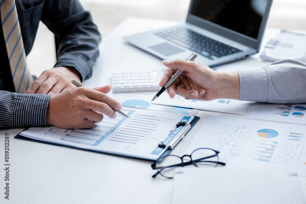 Two businessmen pointed to the material for the meeting, working together to plan to develop and solve common business problems. Concept of business management for growth and quality. Two businessmen pointed to the material for the meeting, working together to plan to develop and solve common business problems. Concept of business management for growth and quality.