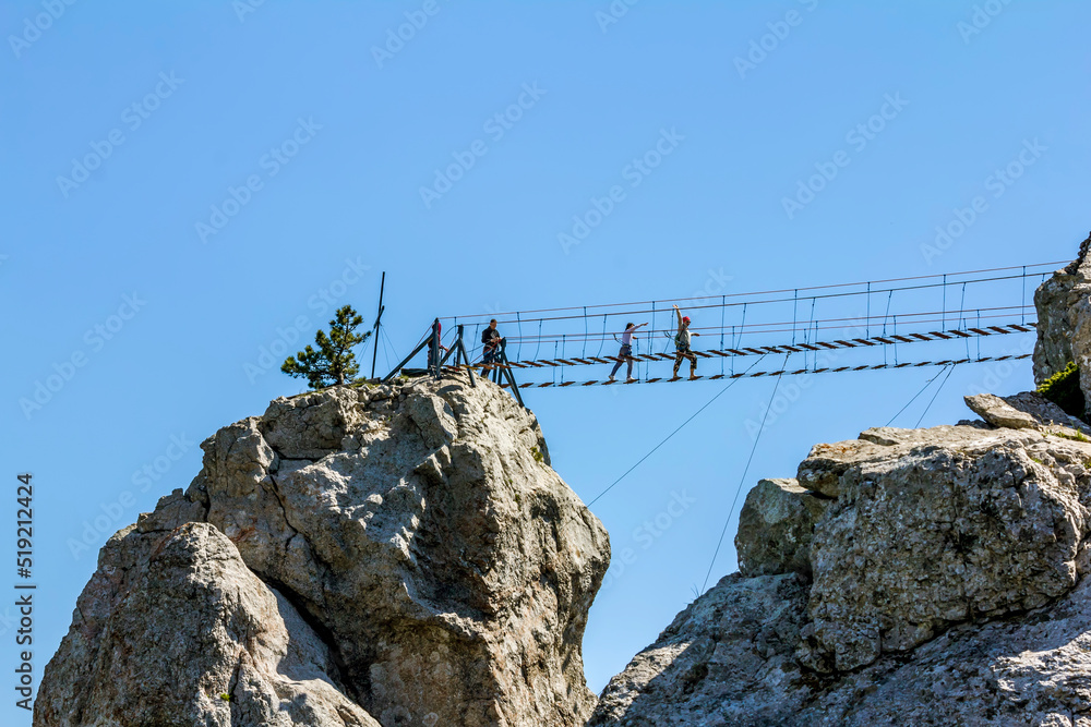 Tourists crossing the abyss on the rope bridge on Mount Ai Petri