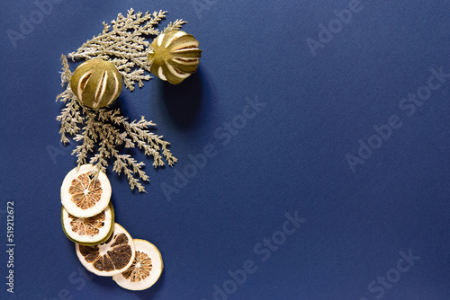 christmas decor on blue background, dried lime, top view, copy space