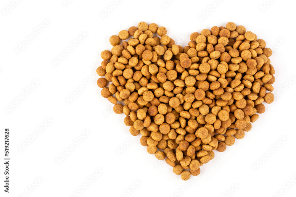 A heart laid out of dry cat food (dogs) on a white isolated background. Space for text. Balanced nutrition of pets. Love for a pet. A heart laid out of dry cat food (dogs) on a white isolated background. Space for text. Balanced nutrition of pets. Love for a pet.