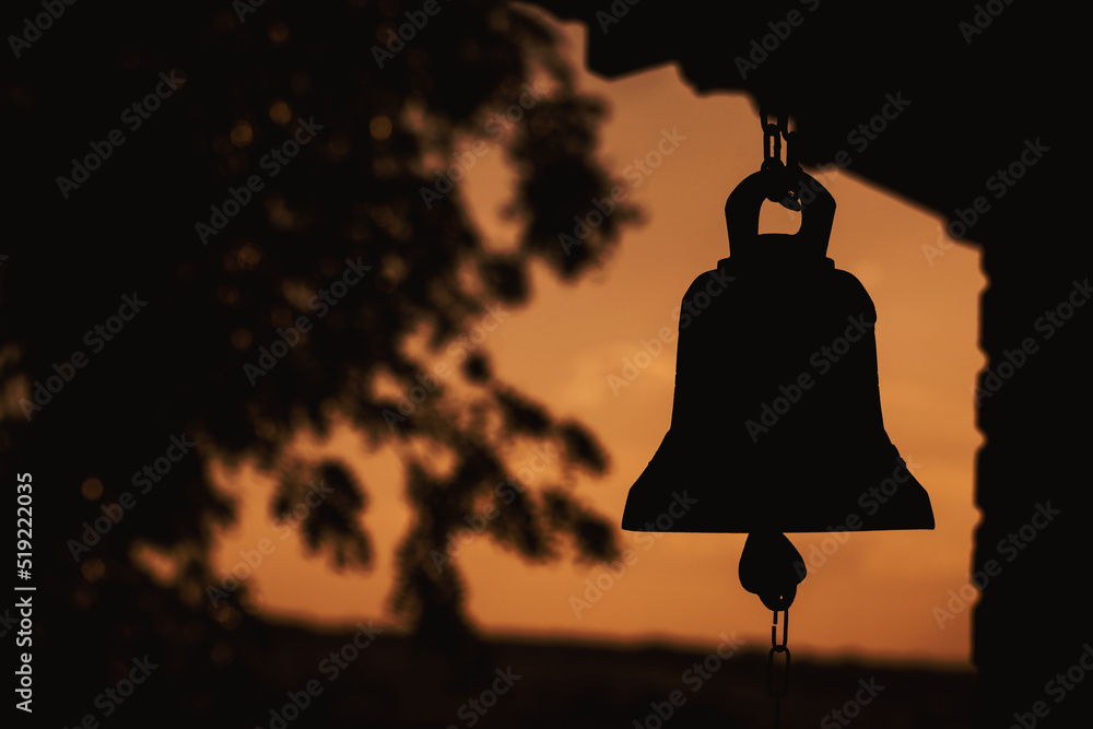 Naklejka premium ancient bell silhouette in church , place of relaxation and worship, sunrise religion concept