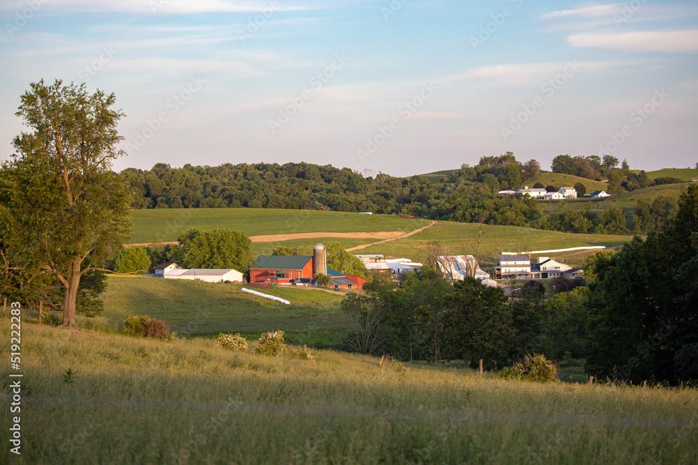 Amish farm in a valley among the rolling hills of Holmes County farmland on a Summer afternoon Amish farm in a valley among the rolling hills of Holmes County farmland on a Summer afternoon
