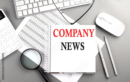 COMPANY NEWS text on notepad on chart with keyboard and calculator on grey background