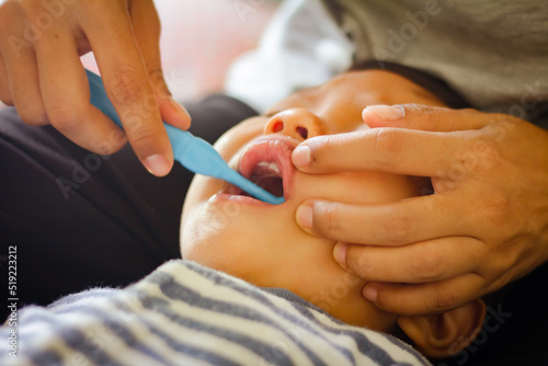 Boy doesn't like brushing his teeth and is sad, baby with her mother and brushing teeth