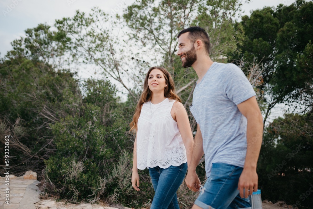 A Hispanic man and brunette woman are strolling in the highland park in Spain A Hispanic man and brunette woman are strolling in the highland park in Spain