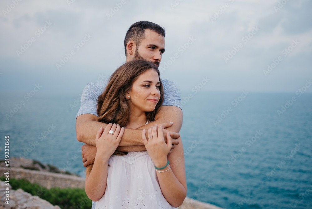 A man is hugging his girlfriend in the highland park near the sea in Spain A man is hugging his girlfriend in the highland park near the sea in Spain