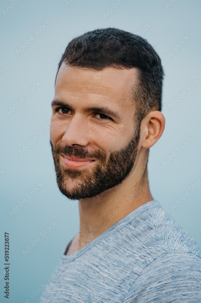 Fototapeta premium A Hispanic man with a beard near the sea in a highland park in Spain