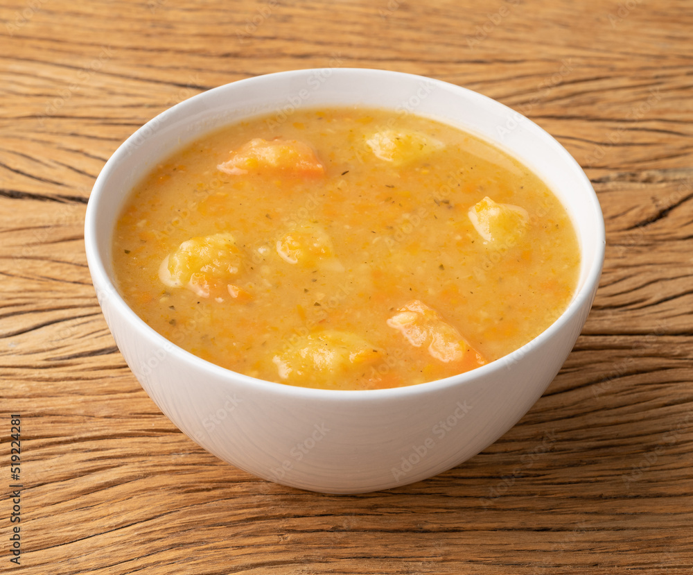 Vegetable soup in a bowl over wooden table Vegetable soup in a bowl over wooden table