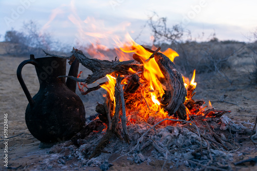 bonfire in the desert, a charred black kettle for boiling water. Karakum, Turkmenistan photo