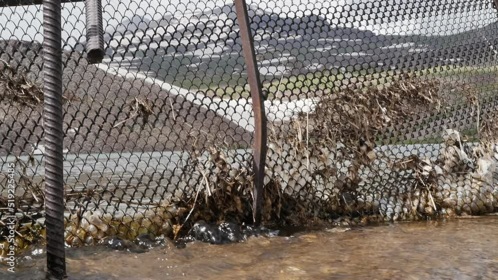 A metal mesh is stretched over a dam in a mountain lake and serves as a water filter to trap debris, old leaves and branches when water is discharged from the lake. Clean water flow from the lake A metal mesh is stretched over a dam in a mountain lake and serves as a water filter to trap debris, old leaves and branches when water is discharged from the lake. Clean water flow from the lake