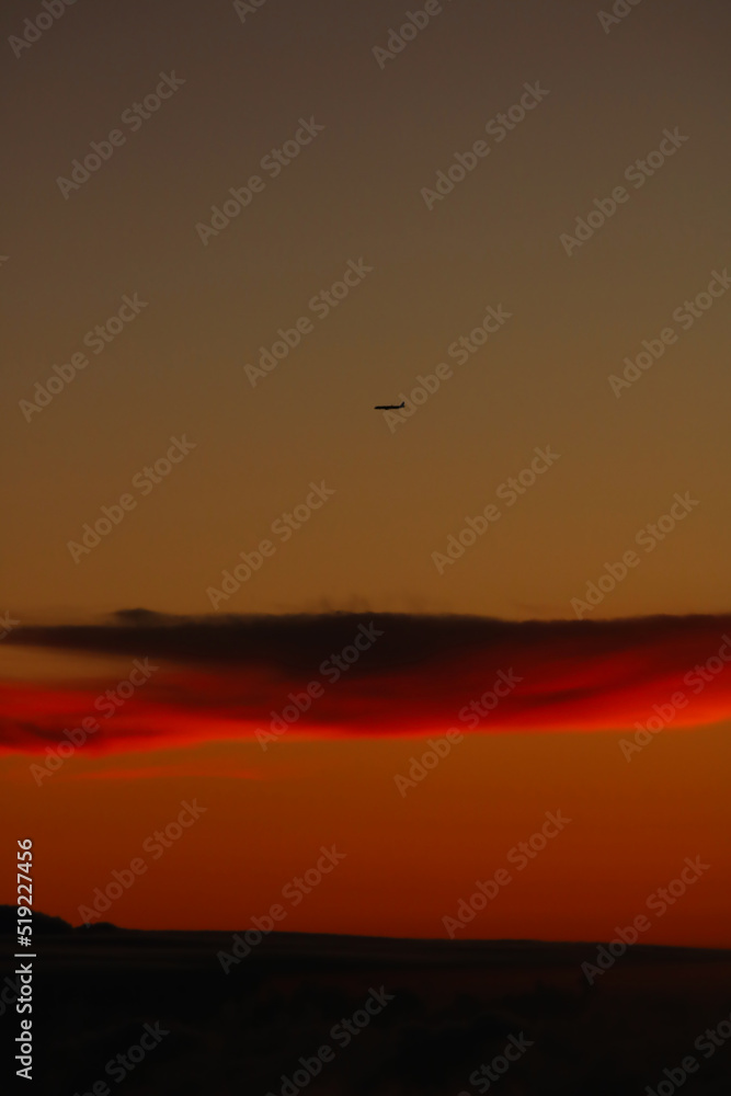 Plane over a cloud in sunset