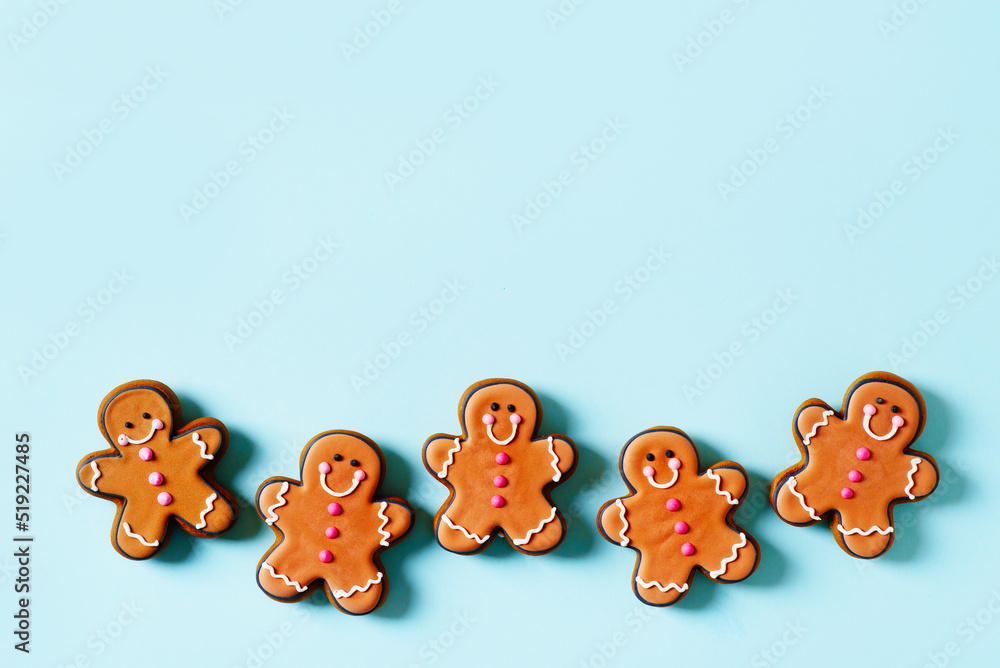 Row gingerbrads men on stick on blue background Row gingerbrads men on stick on blue background