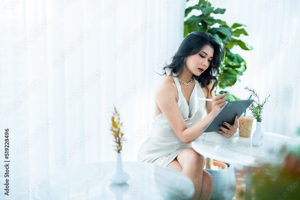 beautiful asian freelance Success people business woman fashion model in summer white sleeveless dress using casual working with tablet for browsing internet, chatting and blogging in coffee shop. beautiful asian freelance Success people business woman fashion model in summer white sleeveless dress using casual working with tablet for browsing internet, chatting and blogging in coffee shop.