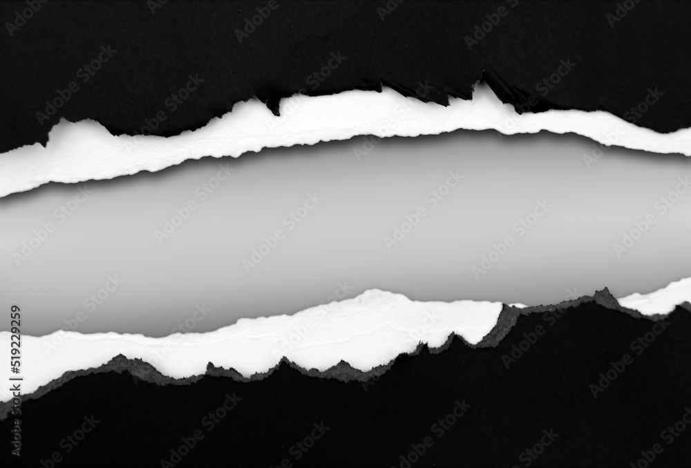 Ripped black paper on grey background, space for copy Ripped black paper on grey background, space for copy