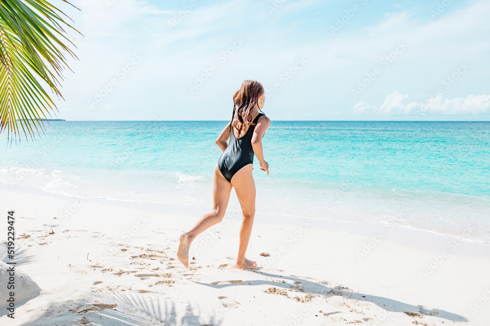 teenage girl with red hair in swimsuit run along the beach in the Maldives, a travel concept teenage girl with red hair in swimsuit run along the beach in the Maldives, a travel concept