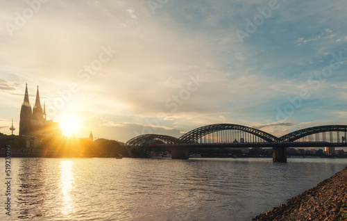 embankment of Rhine on background of Cologne Cathedral and Hohenzollern Bridge in Cologne Koel, Germany at sunset. Tourism and travel by Germany.. © Iryna