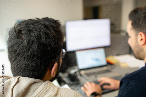 Two business people working with computer in office. No people face in photo.