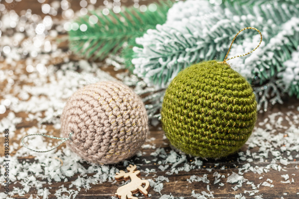Crocheted Christmas balls and holiday decor. Snow-covered fir tree branches Crocheted Christmas balls and holiday decor. Snow-covered fir tree branches