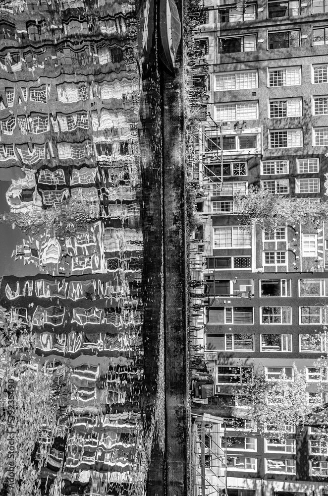 Reflection of the buildings along the canal in Amsterdam, the Netherlands. Black and white image