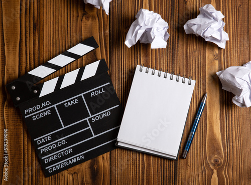 paper and a crumpled paper with cinematic clapperboard on a table
