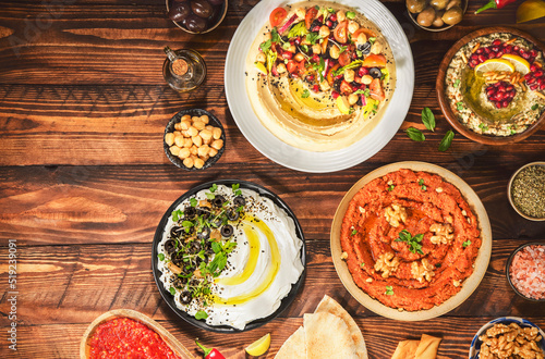 Arabic Cuisine  Varieties of delicious Middle Eastern meze and dips. hummus plate  muhammara  labneh  baba ghanough  harissa and olives. Served with pita bread and fresh olive oil.