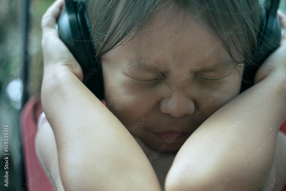 A child afraid of loud sound, covering her ears. Autism and noise sensitivity. A child afraid of loud sound, covering her ears. Autism and noise sensitivity.