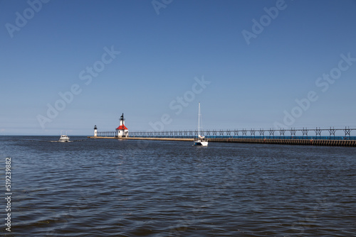 Boats in the channel and St. Joseph North Pier Inner Lighthouse and St. Joseph North Pierhead Outer Lighthouse, Michigan  photo