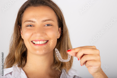 Beautiful smiling young woman with aligner.