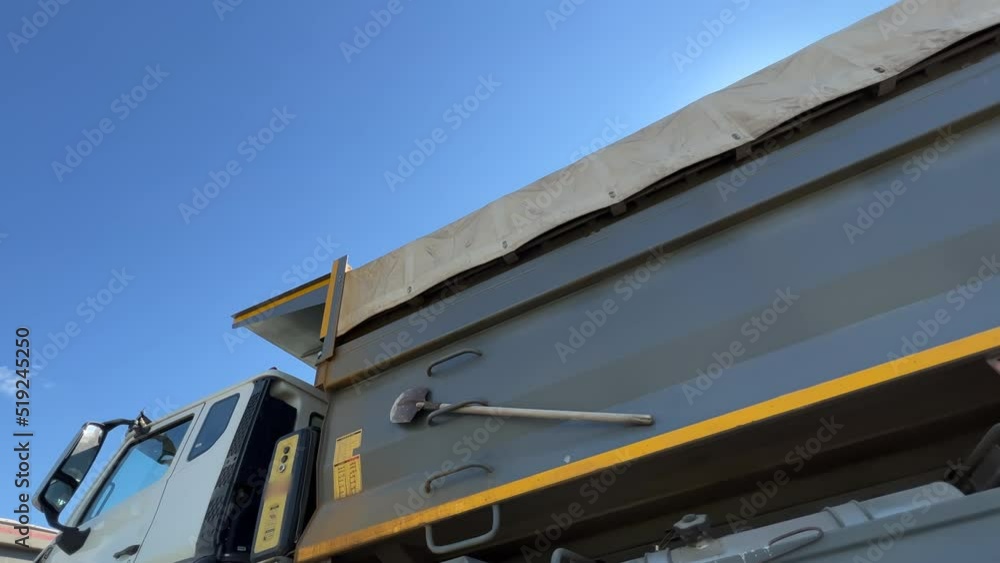 Dump trucks stand at the construction site or quarry waiting for unloading. Low angle view. Extreme wide angle shot Dump trucks stand at the construction site or quarry waiting for unloading. Low angle view. Extreme wide angle shot