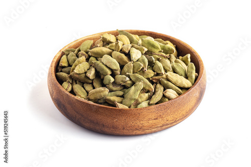 Green cardamom pods in a wooden bowl