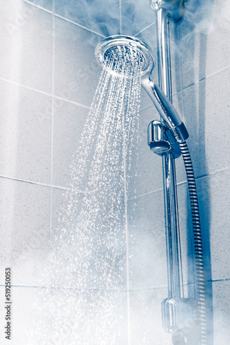contrast shower with flowing water and steam, blue background © nikkytok